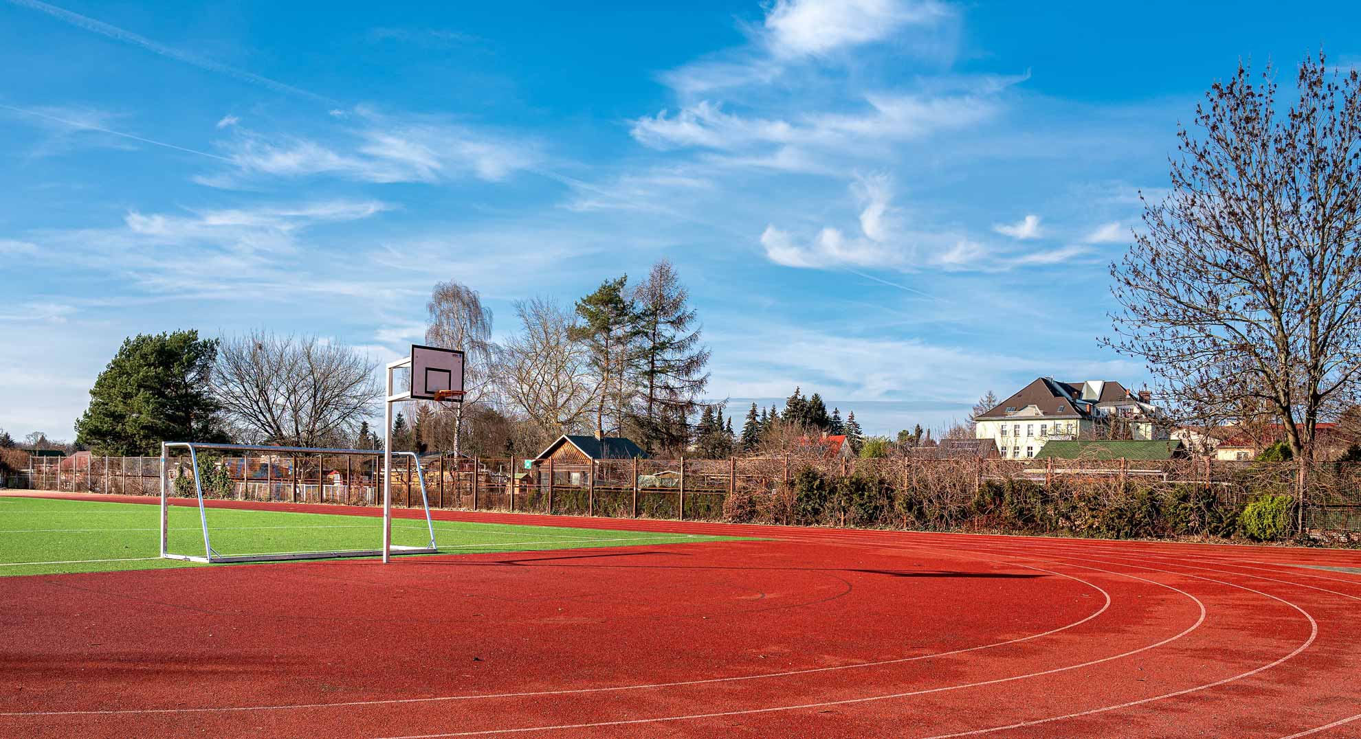 Großer Sportplatz mit Laufbahn und Rasenfläche